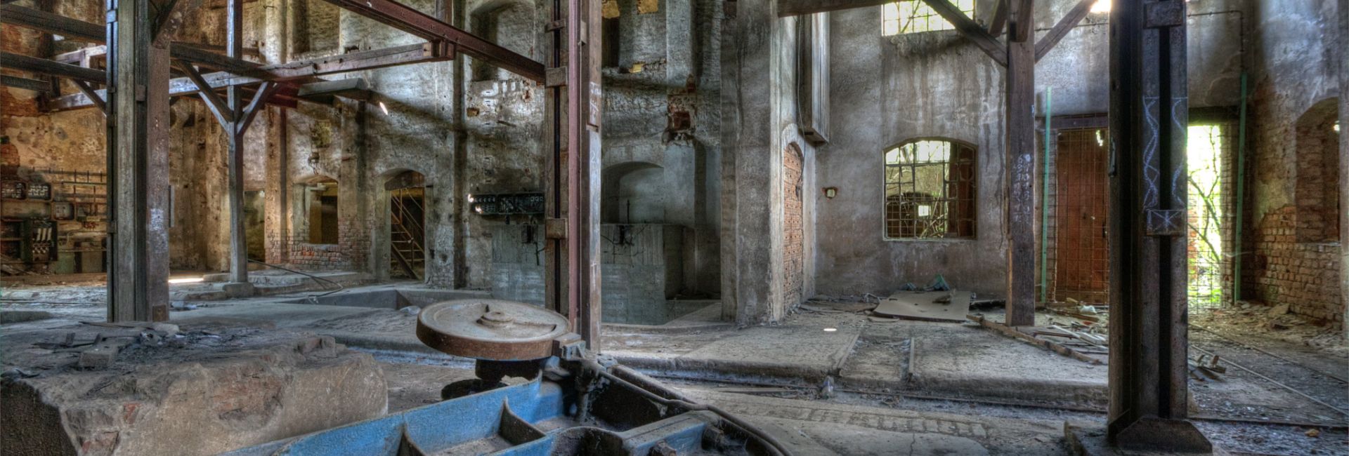 Alte Fabrikhalle mit Rost, Holz und zerfallenden Wauern.